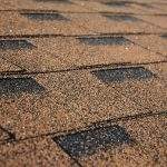 Building new house with asphalt shingle roof. Close up on brown roof shingles as a textured background