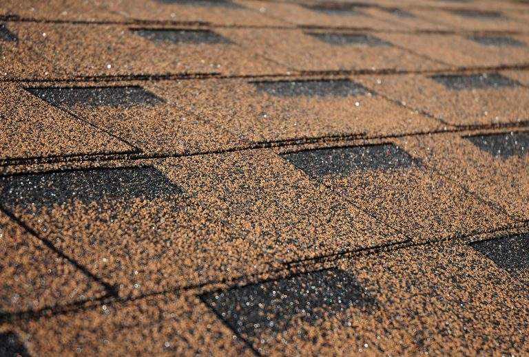 Building new house with asphalt shingle roof. Close up on brown roof shingles as a textured background