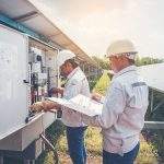 two engineer working on checking and maintenance equipment at green energy solar power plant: cheking status inverter