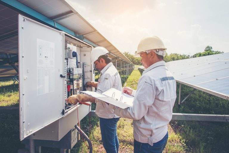 two engineer working on checking and maintenance equipment at green energy solar power plant: cheking status inverter