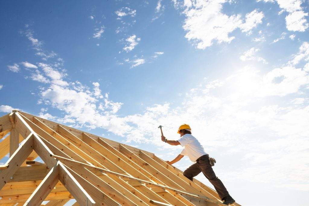 roofer carpenter working on roof structure on building site