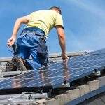 Installing solar photovoltaic panel system. Solar panel technician installing solar panels on roof. Alternative energy ecological concept.