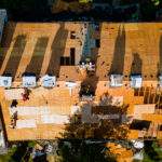 Construction worker on a replacement shingles roof the house installed new shingles of residential building