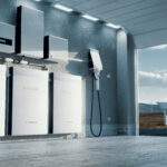 Concept of a home energy storage system based on a lithium ion battery pack situated in a modern garage with  view on a vast landscape with solar power plant and wind turbine farm. 3d rendering.