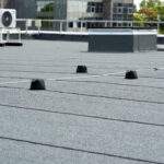 Flat roof covered with bitumen membrane for waterproofing.